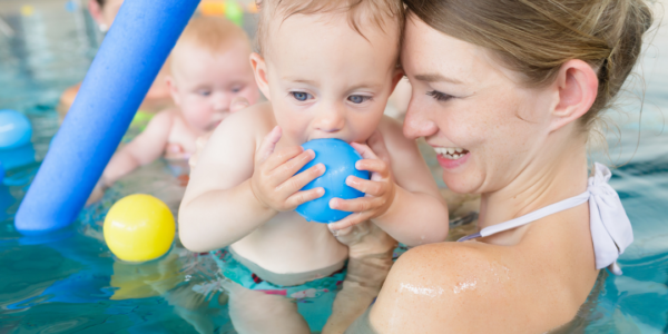 Baby in the pool with mom.