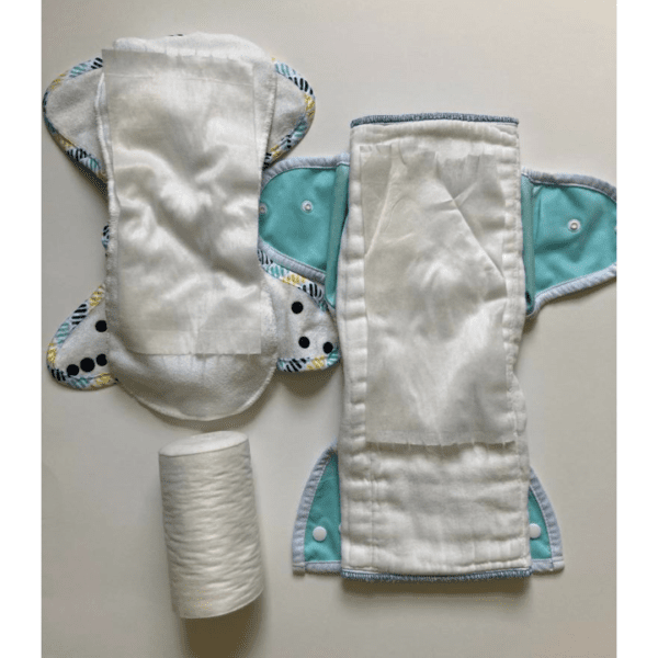 Thin flushable liners layered on top of a cloth diaper pad.