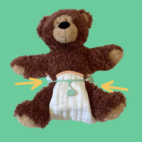 Teddy bear with a prefold diaper that is too small on him. The diaper does not wrap all the way around.